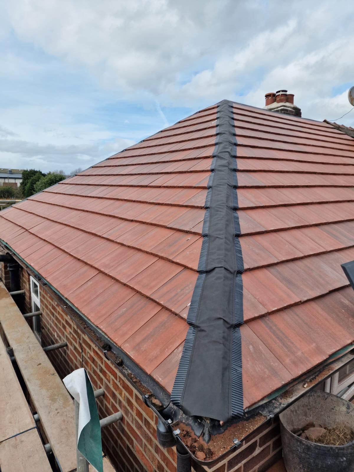 Roofer fitting ridge tiles on a re-roof