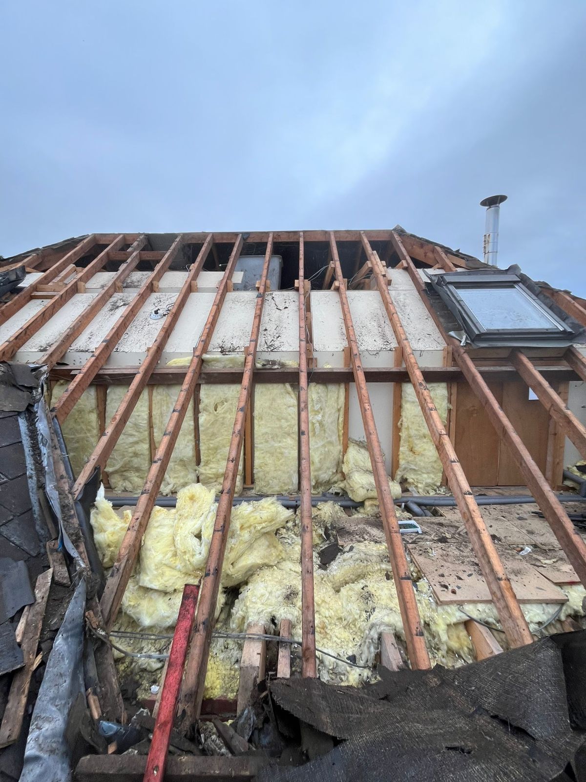 Roof stripped showing joists and loft insulation